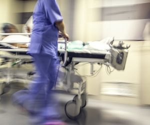 Doctors and nurses pulling hospital trolley,